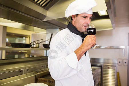 在厨房里喝红酒的男厨玻璃男人男性帽子酒杯厨师酒精白人餐厅制服图片