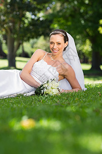 幸福新娘躺在公园的草地上图片