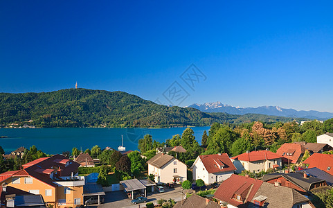 沃瑟西和沃塞西湖的Portschach度假村 奥地利晴天蓝色山脉房屋天空海岸树木支撑图片