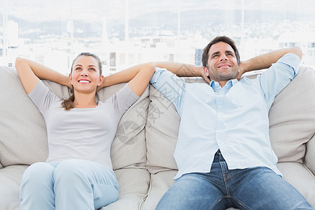 快乐的情侣在沙发上放松长椅家庭女士公寓男性微笑女性闲暇住所客厅图片