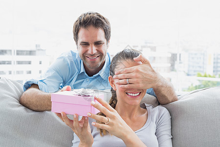 男人用沙发上的粉红礼物 给他女朋友惊喜周年感情展示长椅女士微笑家庭男性女性客厅图片