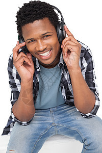 年轻人享受音乐的肖像乐趣爱好耳机快乐牛仔布男人牛仔裤微笑黑色听力图片