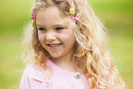 一个在公园微笑的女孩的近身浅色女性闲暇童年金发绿地快乐金发女郎头发图片