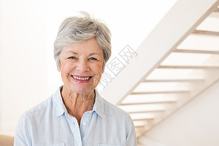 退休的女人对着镜头微笑图片