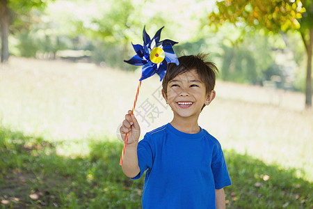 快乐可爱的小男孩 在公园拿着针轮图片