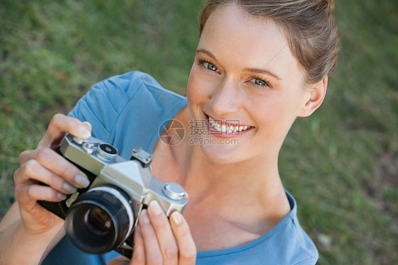 公园中美丽的女摄影师技术快乐幸福摄影女性女士草地绿地爱好微笑图片