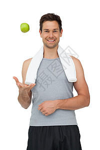 一个微笑的 与苹果相配的年轻人的肖像背心调子运动护理男性水果肌肉绿色闲暇短裤图片
