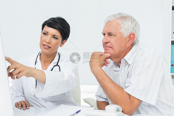医生和男性病人在计算机上阅读报告的报告治疗女士诊所人员成人退休男人卫生电脑保健图片