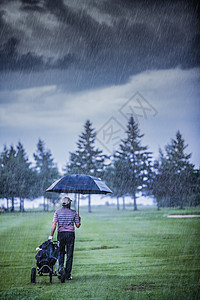 高尔夫球场在雨天时结束淋浴蓝色阵雨退休球道下雨高尔夫球风暴预报男人图片