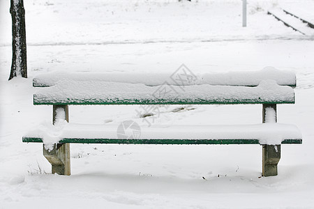 公园中满是雪雪的座椅图片