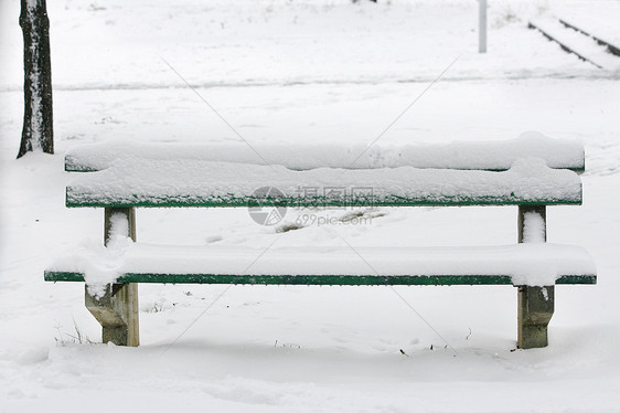 公园中满是雪雪的座椅图片