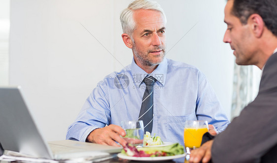 商务人士在吃饭时使用笔记本电脑男人合作商务橙汁人士生意人玻璃同事合伙桌子图片