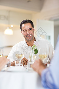 和朋友在餐厅喝酒的笑脸男人酒精微笑朋友们食物白酒友谊男性玻璃图片