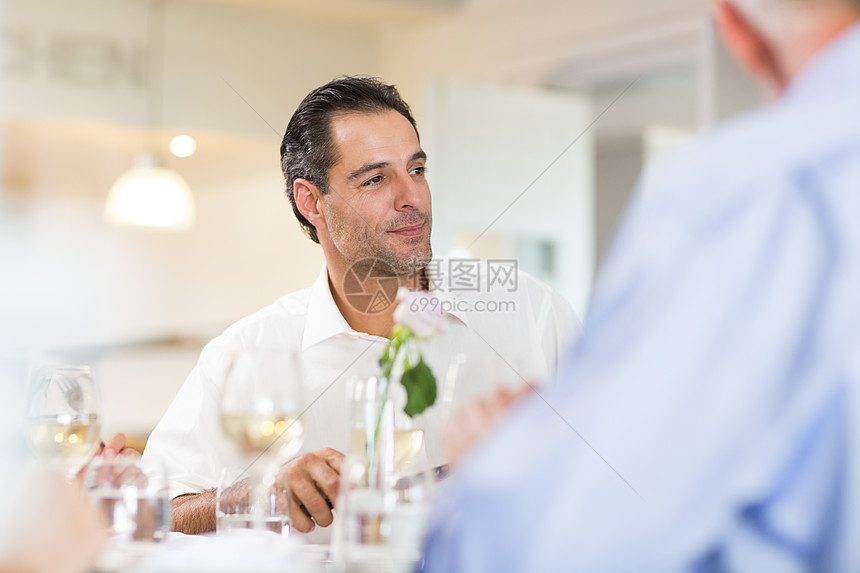 英俊男人和朋友在餐厅喝红酒图片