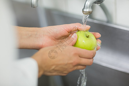 在水龙头下洗苹果厨师图片