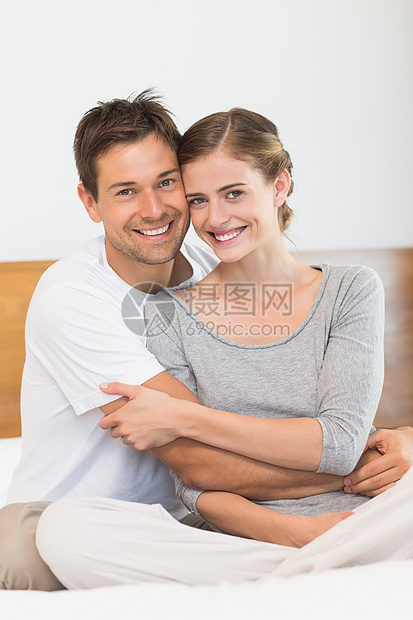 快乐的情侣在镜头前微笑住所幸福夫妻房子男人棉被拥抱感情羽绒被女性图片