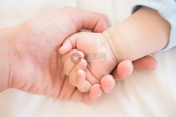 母亲握着孩子儿子的手感情住所幸福公寓婴儿说谎午睡卧室男生新生活图片
