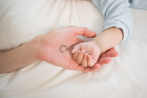 母亲握着孩子儿子的手幸福闲暇新生活公寓住所房子感情卧室男性睡眠图片