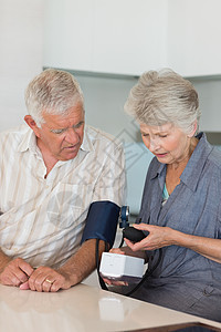 检查丈夫血压的高级女高官专注男人住所退休夫妻家庭老年疾病成人台面图片