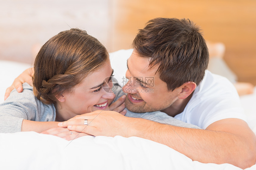幸福的情侣躺在床上女性羽绒被拥抱感情公寓住所家庭卧室夫妻微笑图片