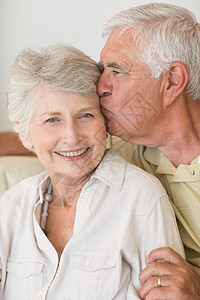 高龄情侣在沙发上一起放松闲暇男人成人公寓老年住所女士退休快乐拥抱图片