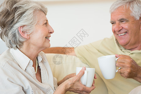 在沙发上一起喝咖啡的老夫妇图片