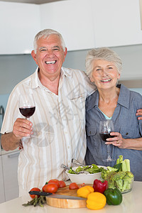 准备一顿饭和喝红酒的老夫妇微笑感情亲密感房子切菜板住所柜台头发老年厨房台面图片