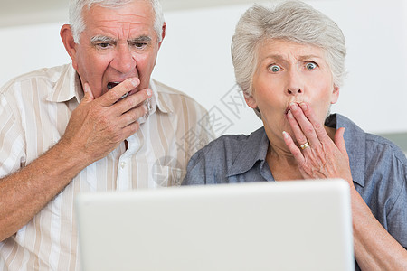 使用笔记本电脑的老年夫妇震惊图片