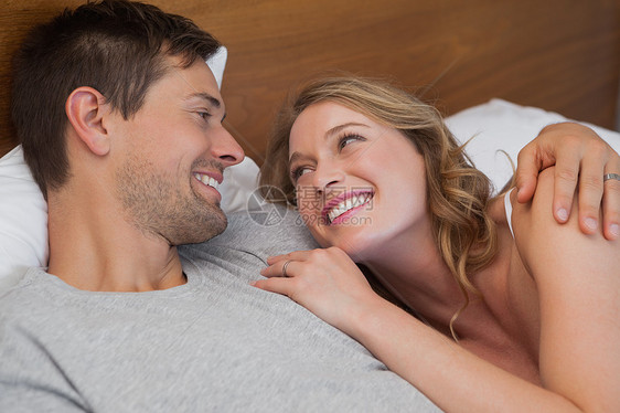 快乐放松的年轻夫妇一起上床睡觉男性房子女性家庭生活亲热闲暇卧室男人女士感情图片