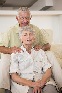 上士给他的搭档做肩膀按摩沙发女士关爱公寓地面女性老年微笑房子退休图片