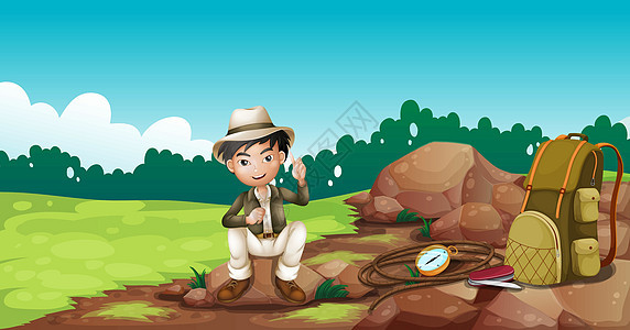 一个男孩 戴着帽子坐在岩石上图片