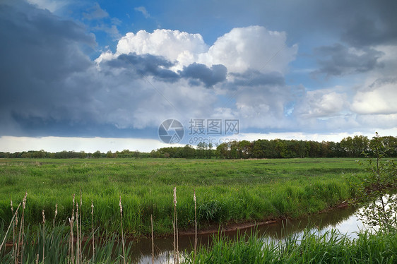 河流上空的暴风雨草地蓝色绿色风景天空农村云景戏剧性风暴沼泽图片