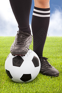 足球运动员的脚足和足球 有天空背景图片