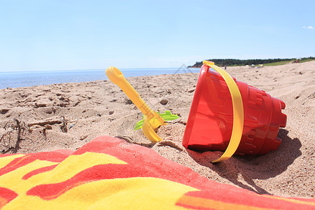 海滩玩具旅行乐趣假期天空晴天海事旅游蓝色红色毛巾图片