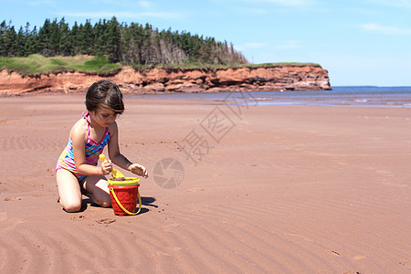 PEI 海滩上的小女孩风景旅行假期晴天海岸线支撑红色海洋海岸旅游图片