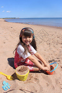 PEI 海滩上的小女孩玩具晴天风景海岸线支撑孩子海洋女性乐趣海岸图片