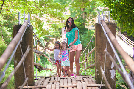 菲律宾洛博克河上悬浮桥上的年轻母亲与她的小女孩在一起 菲律宾Loboc河女孩天桥女士森林危险叶子游客山沟女性穿越图片