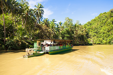 与游客在博霍尔洛博克丛林河上搭乘的外游游船森林河景航程旅行丛林椰子异国热带花园巡航图片