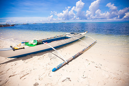 白色热带沙滩上的小型捕鱼船海岸线钓鱼旅游蓝色太阳运输天堂旅行海洋海浪图片