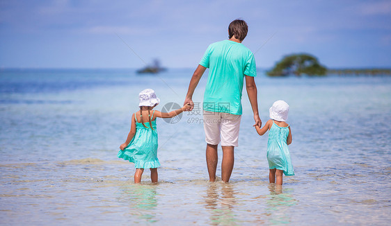 年轻父亲和两个小孩在海边行走的后视线家庭海岸男人异国海洋海滩孩子爸爸假期男性图片