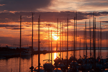 以日落时的游艇为港湾帆船太阳码头钓鱼冒险蓝色天空娱乐光束射线图片