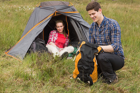 快乐男人打包背包 而女朋友坐在帐篷里图片
