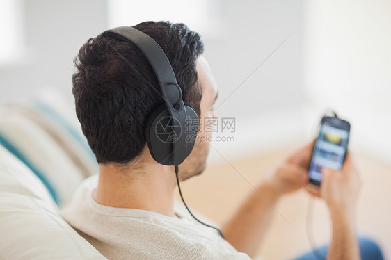 英俊帅哥在智能手机上听音乐图片