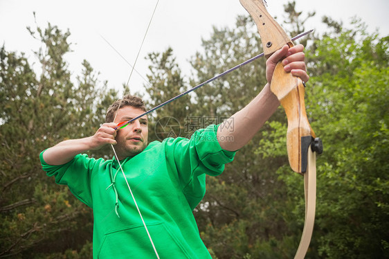 集中力的人练射箭农村竞技男性男人绿色牵引活动专注运动服娱乐图片