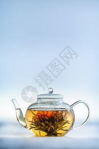 清茶壶中的茶花仪式异国花朵玻璃花瓣茶壶蓝色酿造服务情调图片