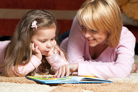 甜美的小女孩 有母亲阅读书说谎妈妈生活女士孩子故事沙发智力家庭女孩图片