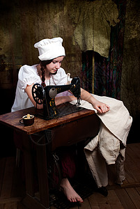 一名年轻缝纫机裁缝匠的肖像女孩材料工具白色蜡烛桌子商业衣服工作贸易图片