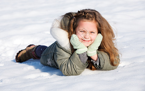女孩在雪中躺下场地衣服帽子婴儿乐趣女性说谎季节夹克快乐图片