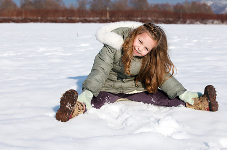 女孩坐在雪中坐着女性公园童年国家微笑衣服喜悦场地夹克帽子图片