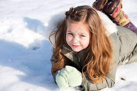 女孩在雪中躺下幸福女性公园乐趣季节帽子说谎喜悦国家童年图片